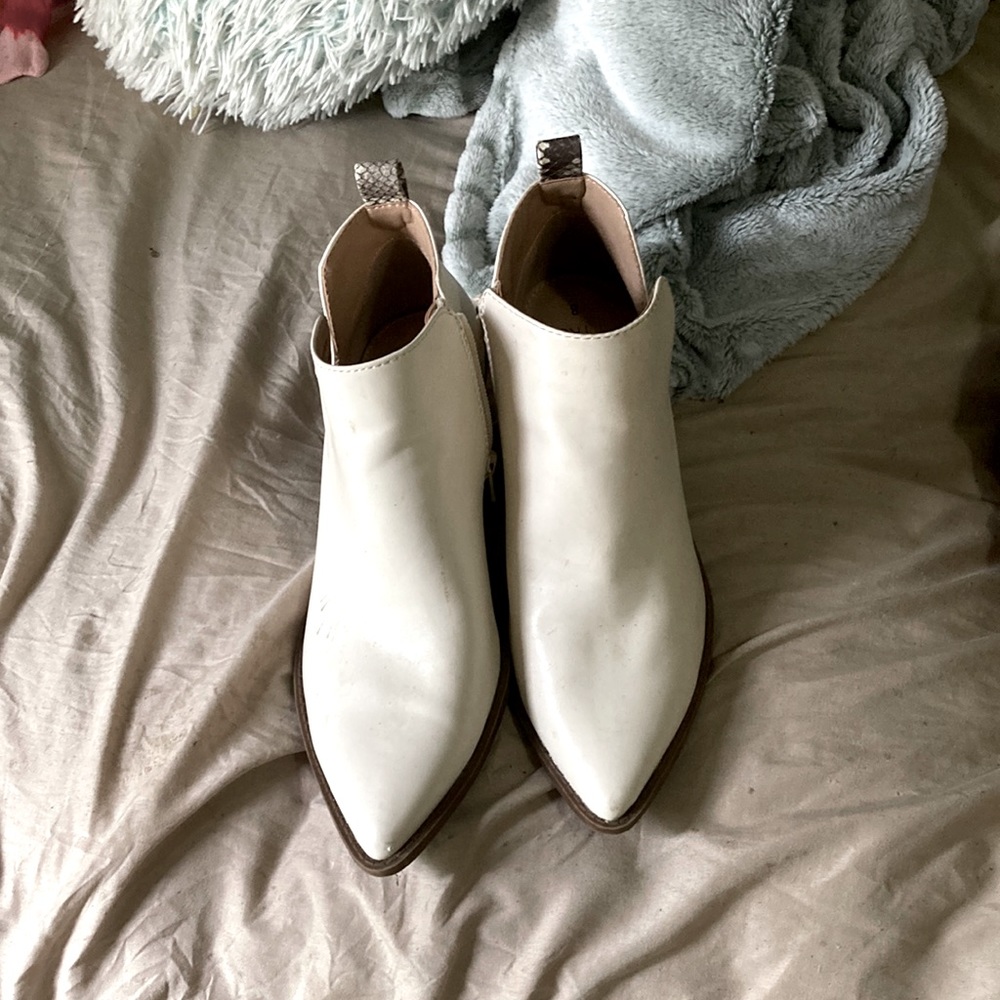 Cream color pointed toe boots with snakeskin strips on the back